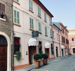una calle con un edificio blanco con macetas. en Hotel De Prati en Ferrara