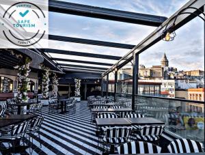 伊斯坦堡的住宿－Ferman Port Hotel - Special Category，阳台餐厅,配有桌椅
