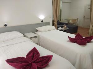 a hotel room with two beds with red flowers on them at Avatara condo A63 by malai in Ban Tha Fat