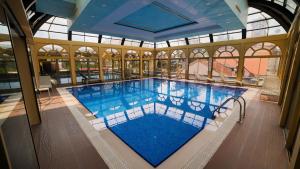 a large swimming pool in a building at Wyndham Batumi in Batumi