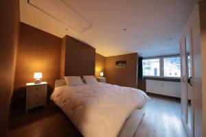 a bedroom with a large bed and a window at la perle grise de la semois in Bouillon