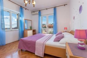 a bedroom with a large bed with blue curtains at Apartments Marija Bibić in Hvar