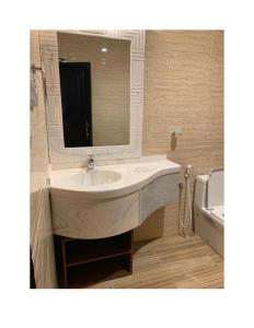 a bathroom with a sink and a mirror and a toilet at Arabian Nights Resort & Spa in Shāhiq