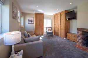 a living room with a couch and a tv at 6 Lakeside Avenue in Thorpeness