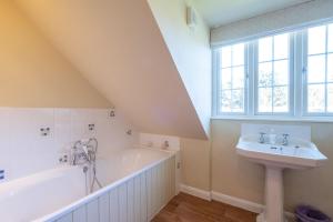 a bathroom with a bath tub and a sink at 6 Lakeside Avenue in Thorpeness +27 photos