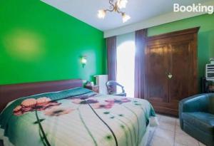 a green bedroom with a bed and a chair at B&B Casa Roman in Zonhoven