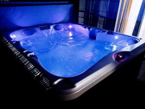 BLACKPEARL apartment في سبليت: حوض استحمام أزرق مع أضواء في الغرفة