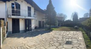 a house with a balcony and a stone patio at B&B Caselle in Caselle Torinese