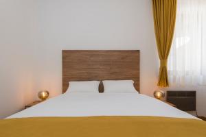 a bedroom with a large bed with a wooden headboard at Vila S6 in Zlatibor