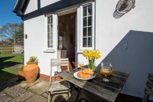 a table with a plate of food and glasses of wine at 6 Lakeside Avenue in Thorpeness