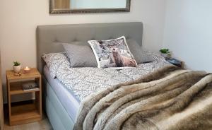 - un lit avec une couverture et un oreiller dans l'établissement Village Romantic Apartment by Český Krumlov - adults only, à Střížov