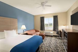 a hotel room with a bed and a chair at Baymont by Wyndham Ft. Leonard/Saint Robert in Saint Robert +36 photos