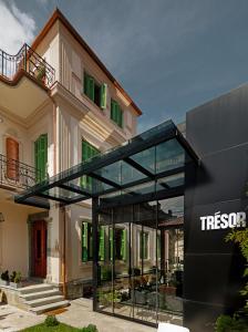 ein Haus mit einer Glaserweiterung davor in der Unterkunft Trésor Art Boutique Hotel in Korçë