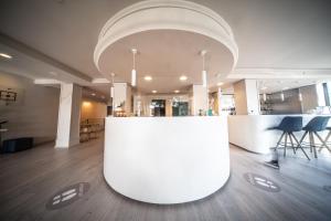 a lobby with a large white counter in a building at Le Grazie Hotel in Assisi