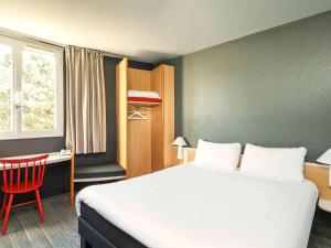 a bedroom with a bed and a desk and a chair at ibis Chartres Ouest Luce in Chartres