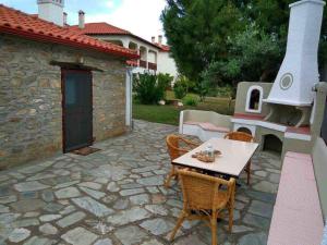 a patio with a table and chairs and a fireplace at Petra House in Nikiti