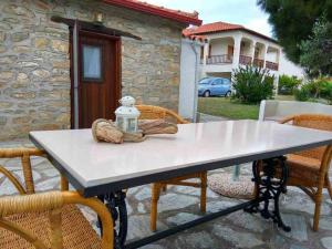 a table with chairs and a bottle on top of it at Petra House in Nikiti