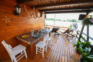 a wooden deck with a table and chairs at Sagando - Floating house on Sava river in Belgrade