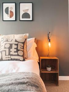 een slaapkamer met een bed en een lamp op een tafel bij Grosvenor House by Solace Stays in Newport