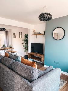 a living room with a couch and a tv at Grosvenor House by Solace Stays in Newport