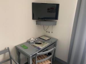 a small table with a television on a wall at Auberge Champenoise in Moussy