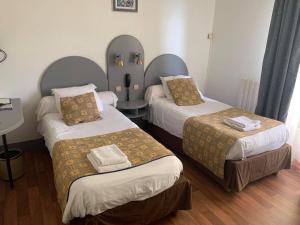 a hotel room with two beds and a table with a table at Auberge de Moussy proche Épernay in Moussy +9 photos