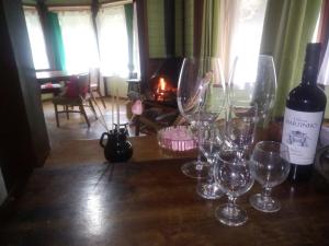 a table with wine glasses and a bottle of wine at Chalé Martinho in Gramado