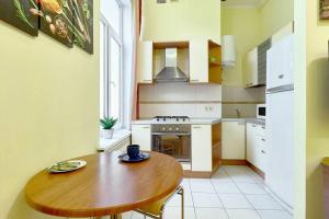 a kitchen with a wooden table and a wooden table and a table at L16 - NICE STUDIO - 1 BEDROOM and 1 LIVING room on MAIN street- COSY APARTMENT IN CENTER CITY near Gulliver Mall in Kyiv