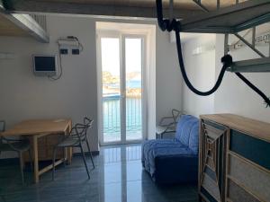 Zimmer mit einem Bett, einem Tisch und einem Fenster in der Unterkunft Agenzia Isotur PESCATORI in Ponza