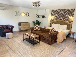 sypialnia z łóżkiem, kanapą i stołem w obiekcie Jardines De La Reina Boutique Bed & Breakfast w Marbelli