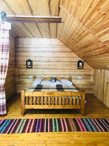 a bed in a wooden room in a log cabin at У Віти номер2 in Synevyrsʼka Polyana