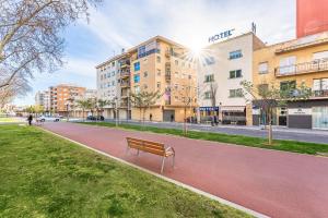 a park with a bench in the middle of a street at Marinada Cambrils in Cambrils