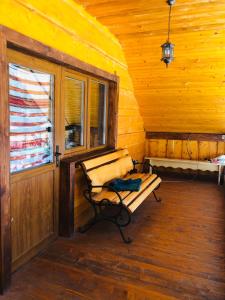 Zimmer mit einer Bank und einem Fenster in einer Hütte in der Unterkunft У Віти номер2 in Synewyrska Poljana