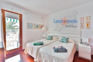 a bedroom with two beds with pillows on them at Vivienda Vacacional Los Molinos 6205 in Costa Teguise