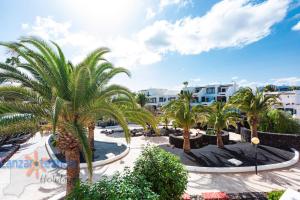 a view of a resort with palm trees and buildings at Vivienda Vacacional Los Molinos 6205 in Costa Teguise