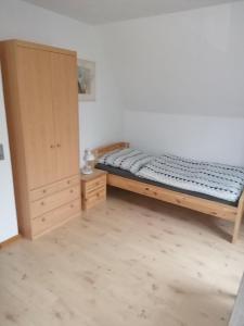 sypialnia z łóżkiem i drewnianą szafką w obiekcie Ellen`s Pension w mieście Dobbrun