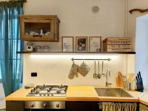 cocina con fogones y fregadero en Le Allegre Comari di Ossuccio, en Ossuccio