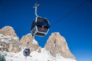 a ski lift in front of a mountain at Hotel Bellevue in Canazei