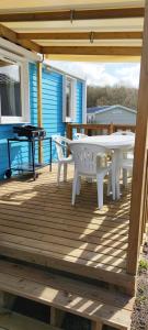 una terraza de madera con una mesa blanca y una parrilla en Assist Mobil home 328 - Mobil Home élégance 3 chambres 6 couchages en Onzain