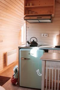een keuken met een oude koelkast en een waterkoker. bij Igluhut De Keet, in Natuurgebied en vlakbij het Strand in Callantsoog