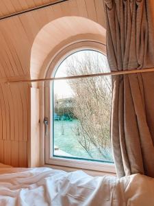 Un dormitorio con una ventana abovedada y una cama en Igluhut De Keet, in Natuurgebied en vlakbij het Strand, en Callantsoog