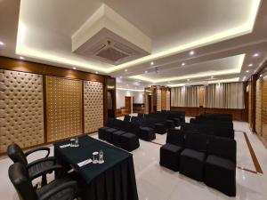 a banquet hall with black chairs and tables in a room at LP Residency in Dehradun