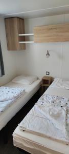 two beds in a room with at Assist' Mobil Home 348 - mobil home 3 chambres tout confort in Onzain