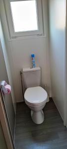 a white toilet in a bathroom with a window at Assist' Mobil Home 348 - mobil home 3 chambres tout confort in Onzain