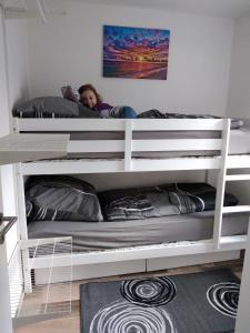 ein kleines Mädchen, das auf dem oberen Etagenbett liegt in der Unterkunft Am Schwielochsee 2 in Speichrow