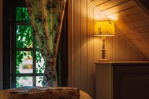 eine Lampe in einem Raum neben einem Fenster in der Unterkunft Domki Victoria in Sasino