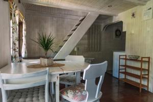 uma sala de jantar com uma mesa e cadeiras e uma escadaria em Domki Victoria em Sasino