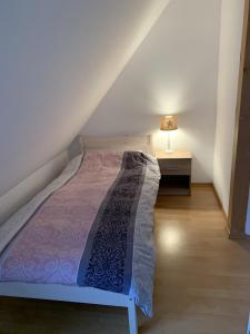 1 dormitorio con 1 cama y 1 lámpara en una mesa en Ferienwohnung Mühlendamm en Bergen