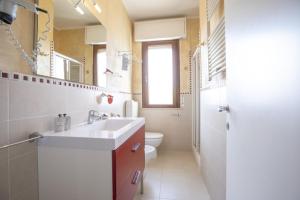 bagno con lavandino, servizi igienici e specchio di Hotel Deborah a Milano Marittima