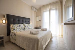 a bedroom with a large bed with two towels on it at Hotel Deborah in Milano Marittima
